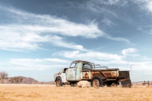 Abandoned derelict old car in the sandy desert